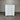 White dresser with multiple drawers against a corrugated metal wall.