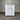 White dresser with multiple drawers against a corrugated metal wall.