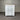 White dresser with multiple drawers against a corrugated metal wall.