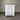 White dresser with multiple drawers against a corrugated metal wall.