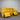 Yellow sofa with reclining feature against a metallic wall.