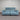 Blue power sofa with black metal legs, against a striped wall