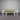 Wooden table and benches against a corrugated metal wall.