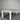 Table with wooden top and white metal legs against a corrugated metal wall.