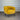 Yellow armchair against a corrugated metal wall.