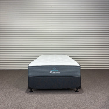 Mattress set with 'Pensavon' branding against a striped wall.