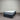 Mattress with 'Chelsea' branding on a gray floor against a corrugated metal wall.