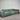 Green sofa against a white paneled wall