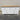 White dresser with wooden top on a gray floor against a beige wall