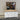 White dresser with wooden top and mirror reflecting a store interior.