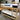 Wooden bunk bed with white mattress in a showroom setting