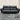 Black leather sofa on a gray floor with a neutral wall background