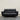 Black leather sofa on a wooden floor with a plain wall background
