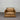Brown leather armchair against a corrugated metal wall.