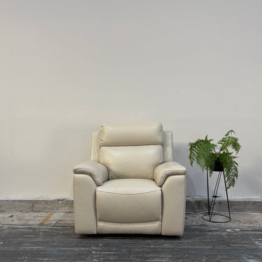 Beige armchair in a minimalistic room with a plant on a gray floor.