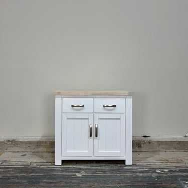 White cabinet with wooden top against a plain wall