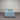 Light blue sofa against a corrugated metal wall.