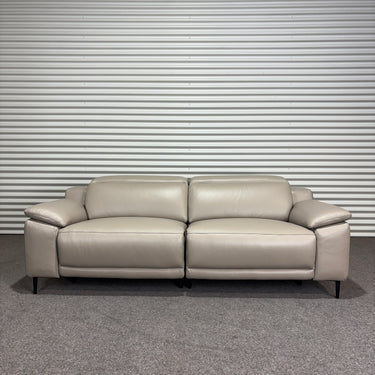 Beige leather sofa against a striped wall.