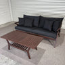 Outdoor furniture set with a sofa and coffee table on a concrete floor.