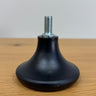 Black rubber foot with a metal screw on a wooden surface