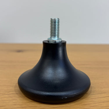 Black rubber foot with a metal screw on a wooden surface