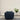 Blue armchair in a minimalistic room with a plant on a stand.