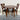 Wooden dining table with two chairs on a rustic wooden floor.
