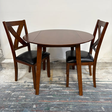 Wooden dining table with two chairs on a rustic wooden floor.