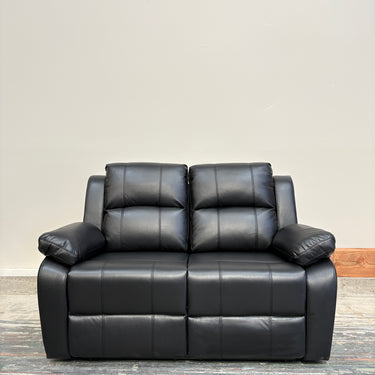 Black leather sofa against a beige wall