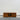 Wooden TV stand with two doors on a wooden floor against a white wall
