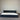 Two mattresses on a gray floor with a corrugated metal wall background