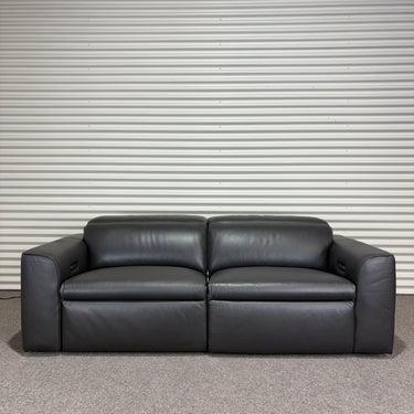 Black leather sofa against a striped wall.