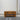 Wooden coffee table with two drawers on a gray floor against a white wall.
