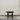 Black square table against a plain white wall.