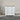 White dresser with black knobs on a wooden floor against a gray wall