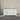 White dresser with black knobs on a gray floor against a plain wall