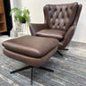 Brown leather armchair with ottoman on a wooden floor