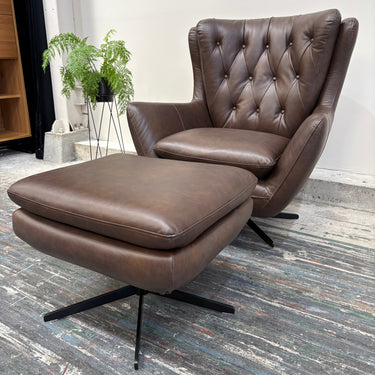 Brown leather armchair with ottoman on a wooden floor