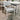 Mantra outdoor dining table and six chairs shown from angle view in matte white anodised aluminium