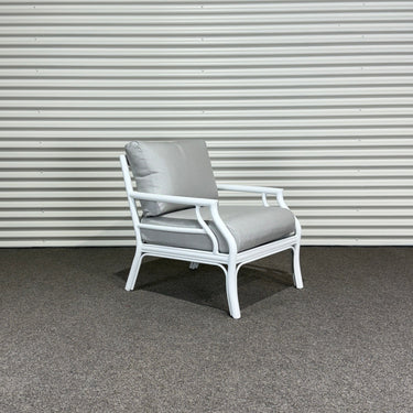 Chair with gray cushion against a corrugated metal wall.
