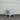White chair with gray cushions against a corrugated metal wall.