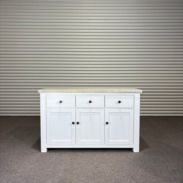 White sideboard with a wooden top against a corrugated metal wall. Kinloch Colletion
