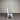 White wooden chair with a gray cushion against a corrugated metal wall. Kinloch Collection