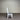 White wooden chair with a gray cushion against a corrugated metal wall. Kinloch Collection