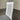 White wooden chair with a gray cushion on a gray floor against a corrugated metal wall. Kinloch collection
