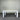 White wooden table against a corrugated metal wall.