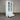 White cabinet with glass doors and a drawer in front of a metallic shutter.