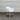 White chair on a gray carpet with a corrugated metal wall in the background
