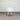 White chair on a gray carpet with a white wall in the background
