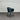 Black chair against a corrugated metal wall.